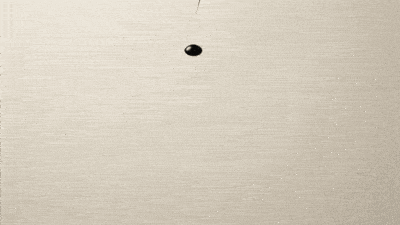An ink oval track on warm paper with a small dark mark on the line.